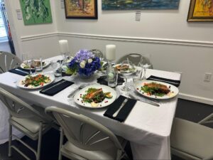 An intimate dining experience set inside an art gallery in St. Augustine, with African contemporary paintings, refined table décor, and a quiet gallery ambiance at Ovico Gallery.
